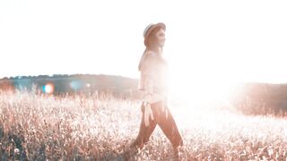Happy Woman Touching Golden Wheat Ears in a Sunny Field