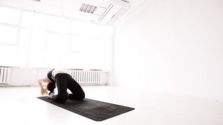 Beautiful Woman in Black Sportswear Doing Yoga on a Gym Mat