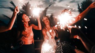 Diverse Group of Women Enjoying a Sparkler Party on a Beautiful Beach