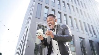 Happy successful African American guy counts, waves, throws, show off, flaunt, cash money background urban city street building. stock video...