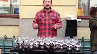 Уличный музыкант виртуозно играет на бокалах с водой