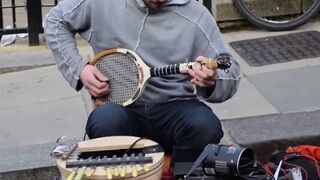 Уличный музыкант играет на теннисной ракетке и не только