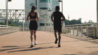 Man and Woman Jogging Together On The Street