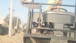 A little boy driving road repairing machine.