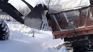 Кировец витаскивает КамАЗ из снега