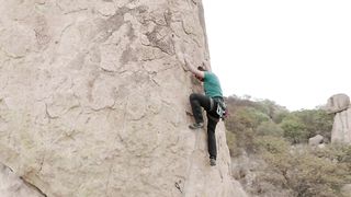 A mountaineer scaling a vertical rock