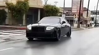 Rolls Royce rolling on rainy day in road with high speed