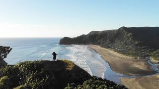 Romantic Couples standing on a rock near Piha Ocean