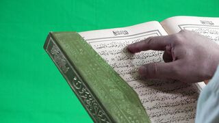 Man reading Quran on green scan
