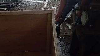 A worker is breaking a wooden box