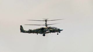 Military Helicopter Shoots a Cannon at Ground Targets