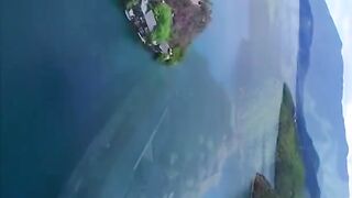 Aerial shot of lake buildings surrounded by mountains