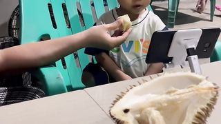 little boy likes to eat durian