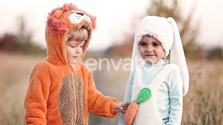 Funny Scene Lion Cub Begins to Gnaw Carrot From Costume of His Bunny Brother