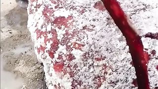 Breaking a red glass slag rock