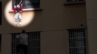 Real-life Spider-Man scales building to rescue toddler who fell out window.