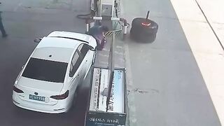 Burning tire rolls into petrol station after falling off truck in China.