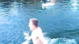 Territorial swan goes after the man swimming in its lake.