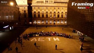 Warga Ukraina memasang tanda di luar teater Praha satu tahun setelah pengeboman Mariupol
