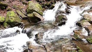 water moves between the stones and small rocks. Natural water is be like.