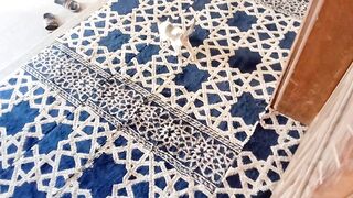 Funny kitten walks on the blue and white carpet