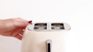 A MAN PUTTING BREAD IN THE TOASTER