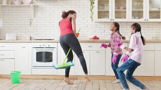 Mother and daughters in a kitchen dancing