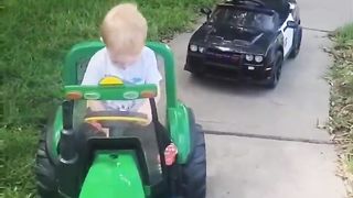 Little boy tows his toy car with his tractor
