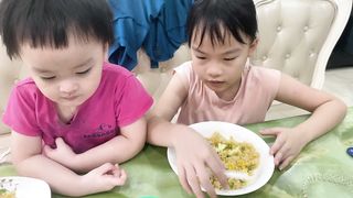 baby with sister eating cơm rang
