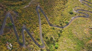 Aerial view of the island of Tenerife - cars driving on a mountain road winding in an arid desert landscape