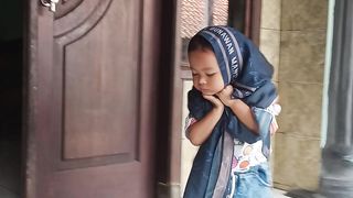 Anak belajar memakai kerudung
